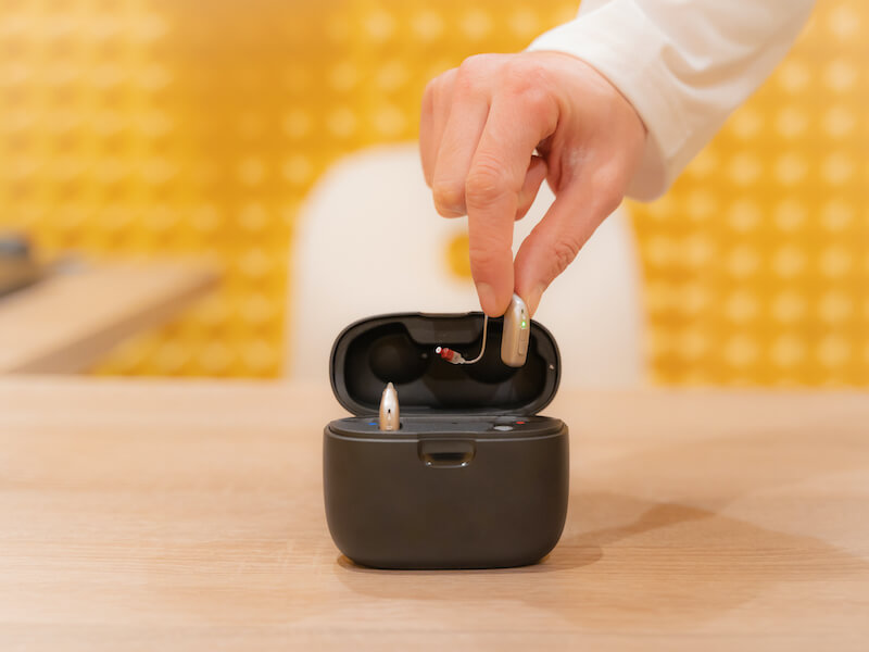 Hand of an audiologist doctor placing a hearing aid in its case