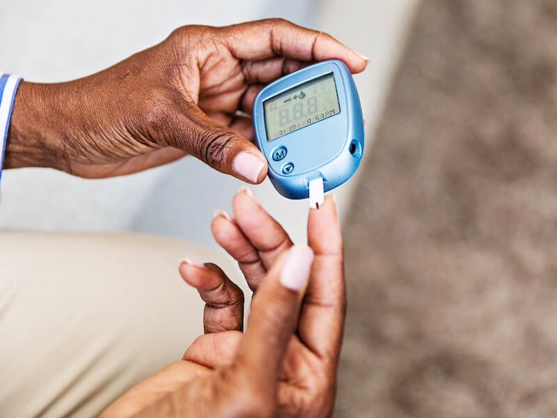 Woman testing her sugar to see if diabetes is affecting her hearing health.