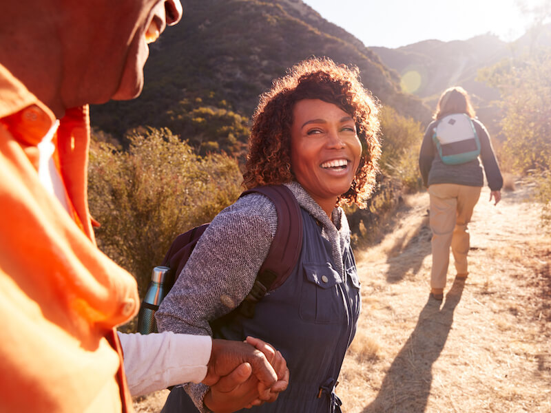 Woman enjoying a hike with friends because she can hear them.