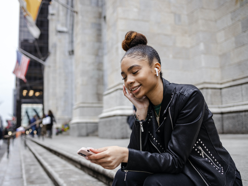 Woman listening to ear buds in danger of hearing loss.