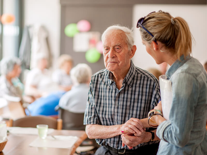 Woman helping her father improve his hearing and cognitive health with hearing aids.